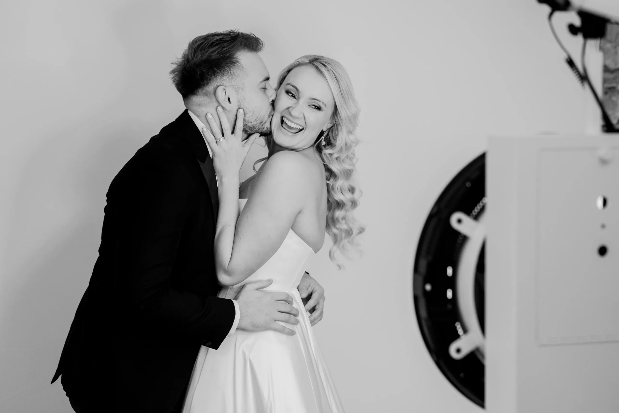 Black and white image of a bride and groom posing in front of the Portrait Photo Booth